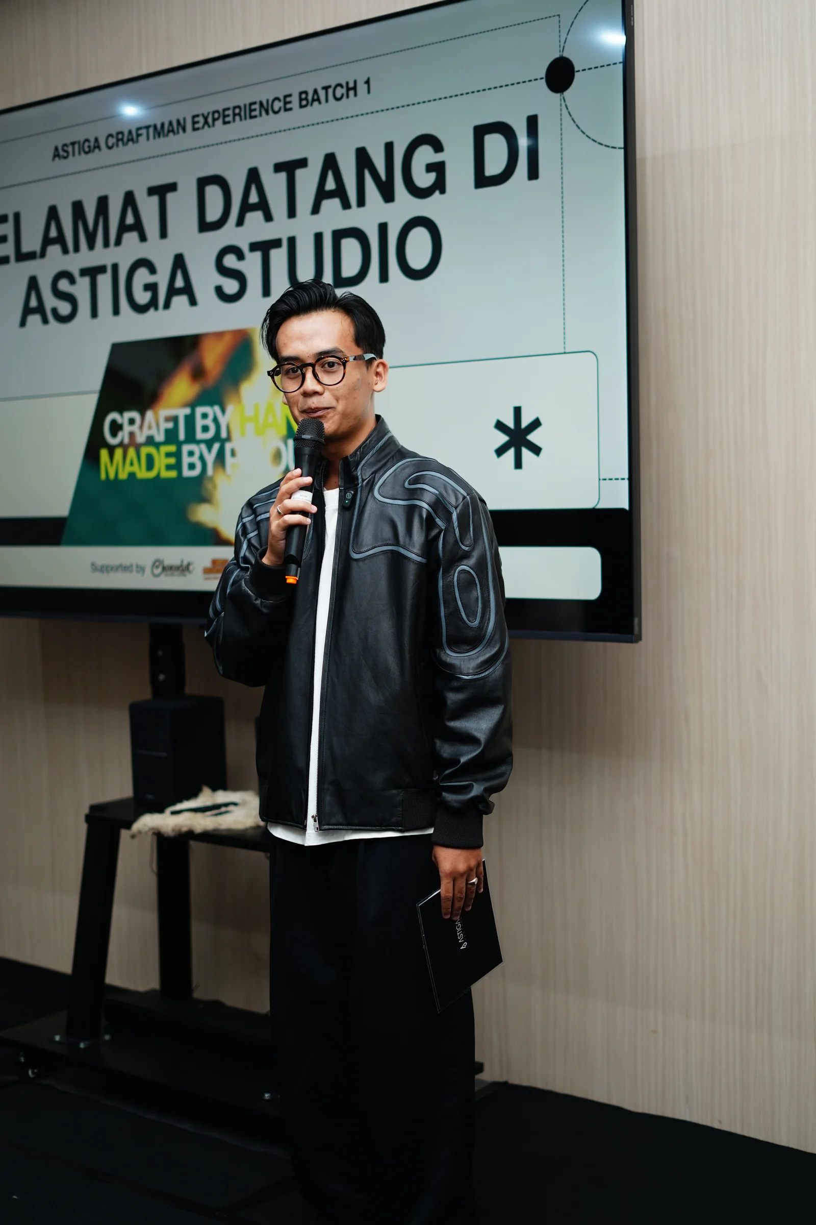 MC Syahril membawakan presentasi di depan layar digital Astiga Studio