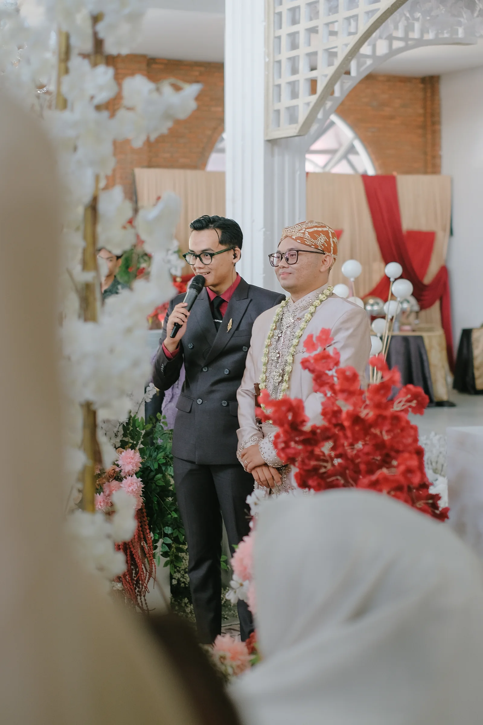 MC Syahril mengarahkan kirab masuk mempelai pria berbusana adat