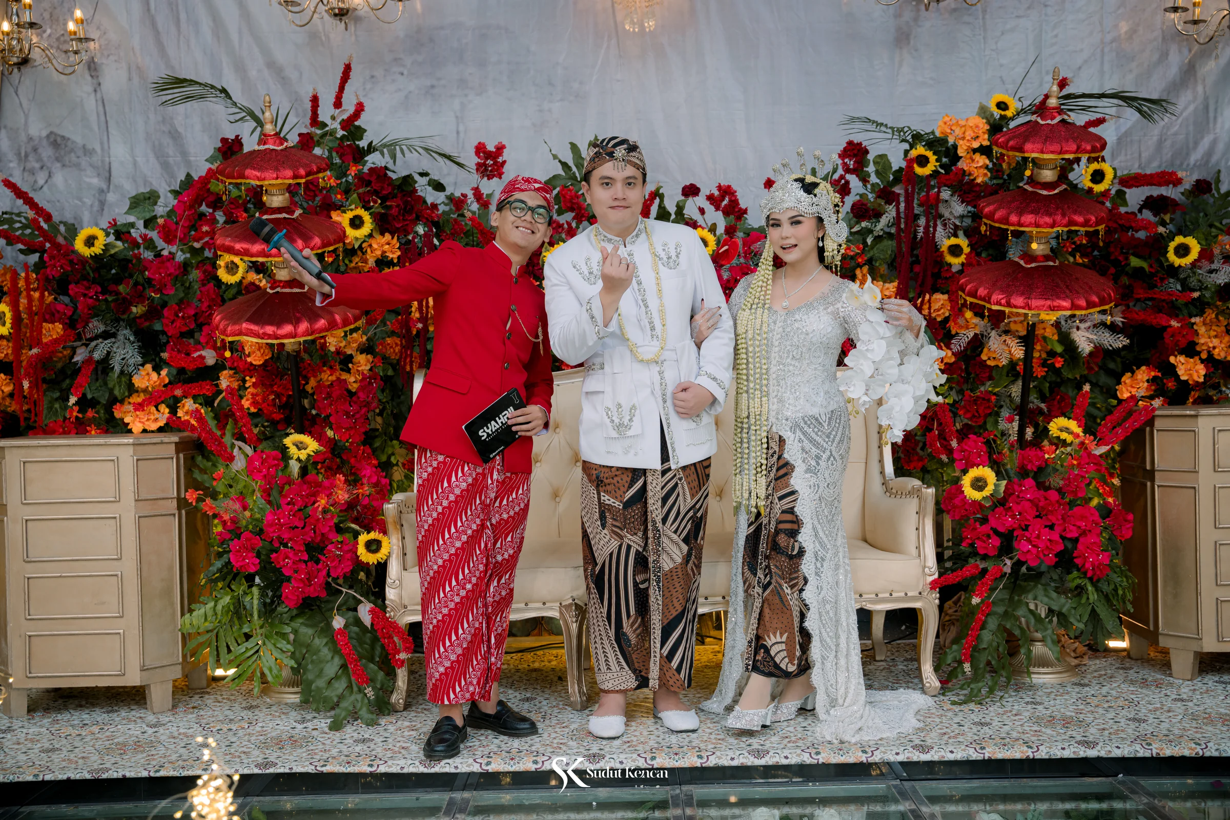 MC Syahril berbeskap merah berpose bersama pengantin berbusana Siger Sunda